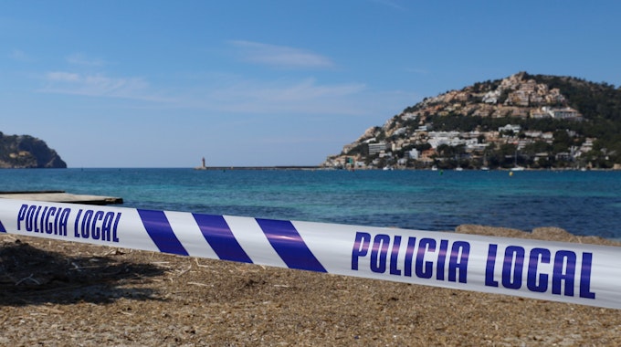 Mit einem Absperrband der Polizei ist der Zugang zu einem Strand auf der Insel Mallorca abgesperrt.