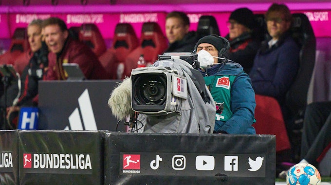 Auf einem Symbolfoto ist ein Kameramann vor der Ersatzbank des FC Bayern München zu sehen