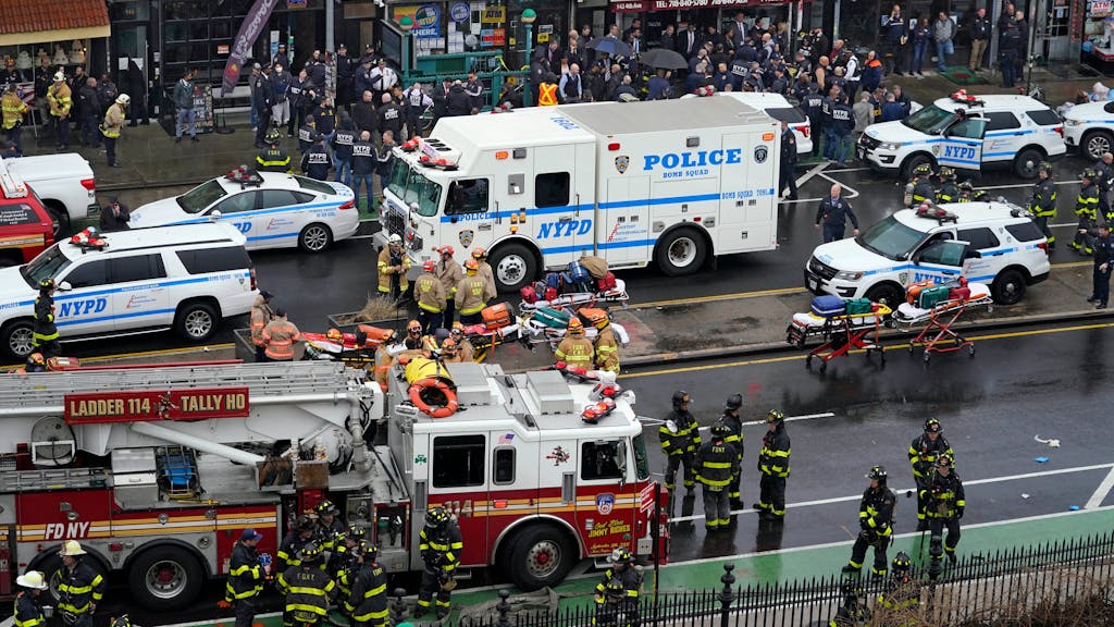 Mitarbeiter des New York City Police Department versammeln sich am Eingang einer U-Bahn-Station im New Yorker Stadtteil Brooklyn. Bei Schüssen in einer New Yorker U-Bahn-Station sind mehrere Menschen verletzt worden.