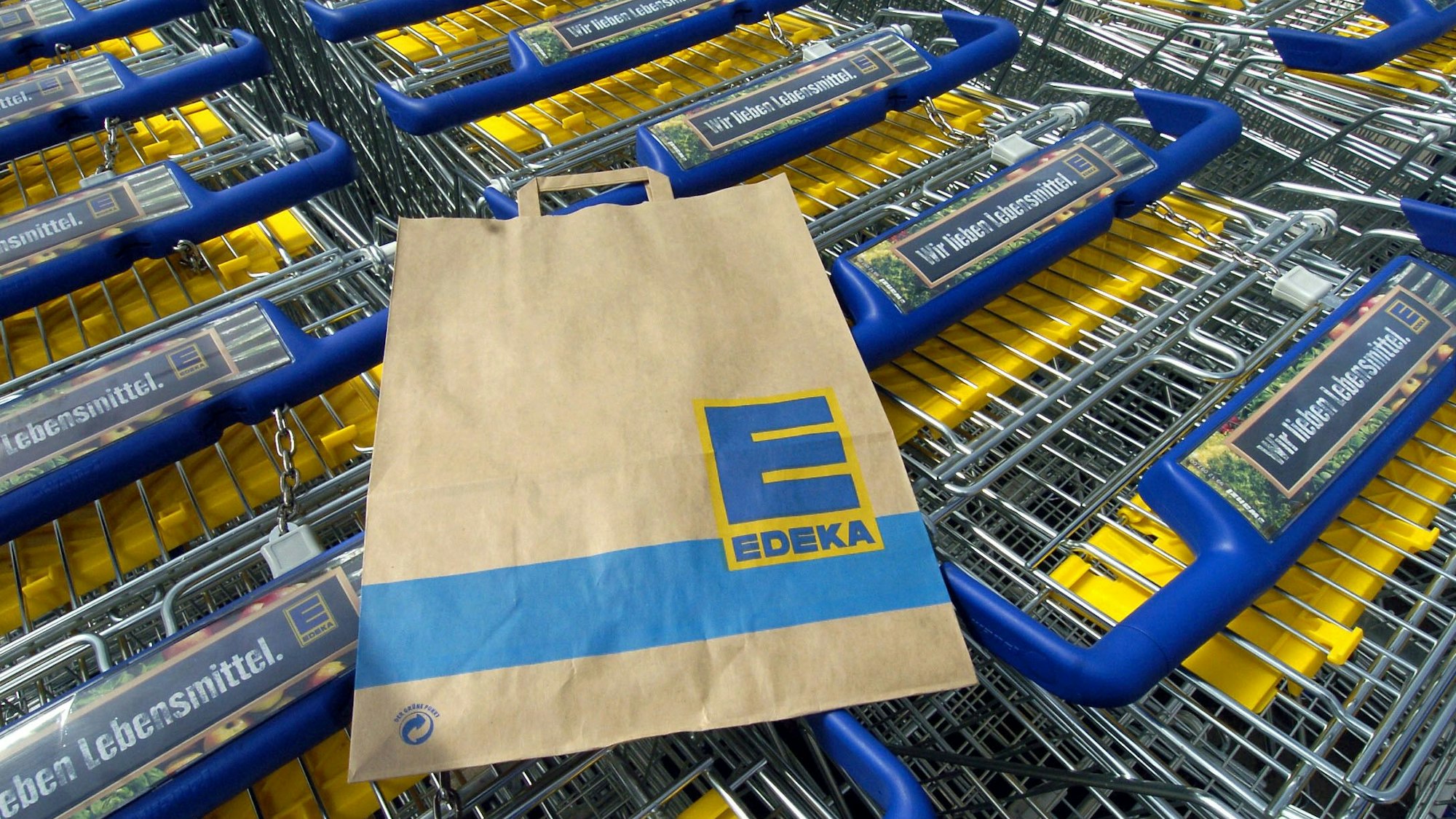 Das Symbolbild zeigt mehrere Einkaufswagen und eine Einkaufstüte des Supermarktes Edeka. Aufgenommen wurde das Bild am28. April 2005.