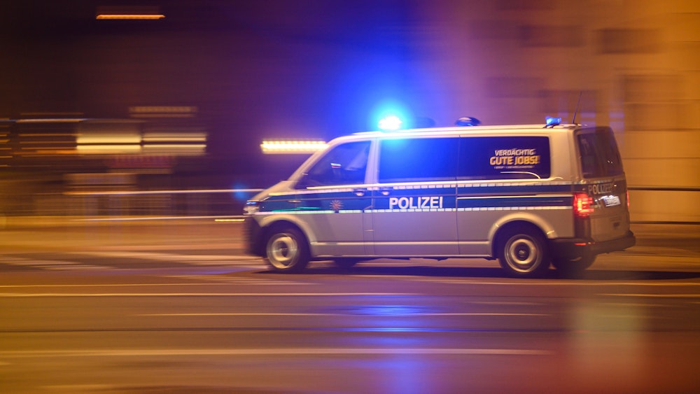 Das Symbolfoto von April 2022 zeigt einen Einsatzwagen der Polizei, der nachts mit Blaulicht fährt.
