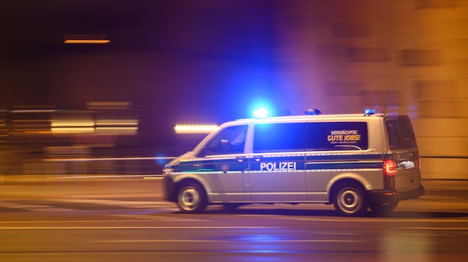 Das Symbolfoto von April 2022 zeigt einen Einsatzwagen der Polizei, der nachts mit Blaulicht fährt.