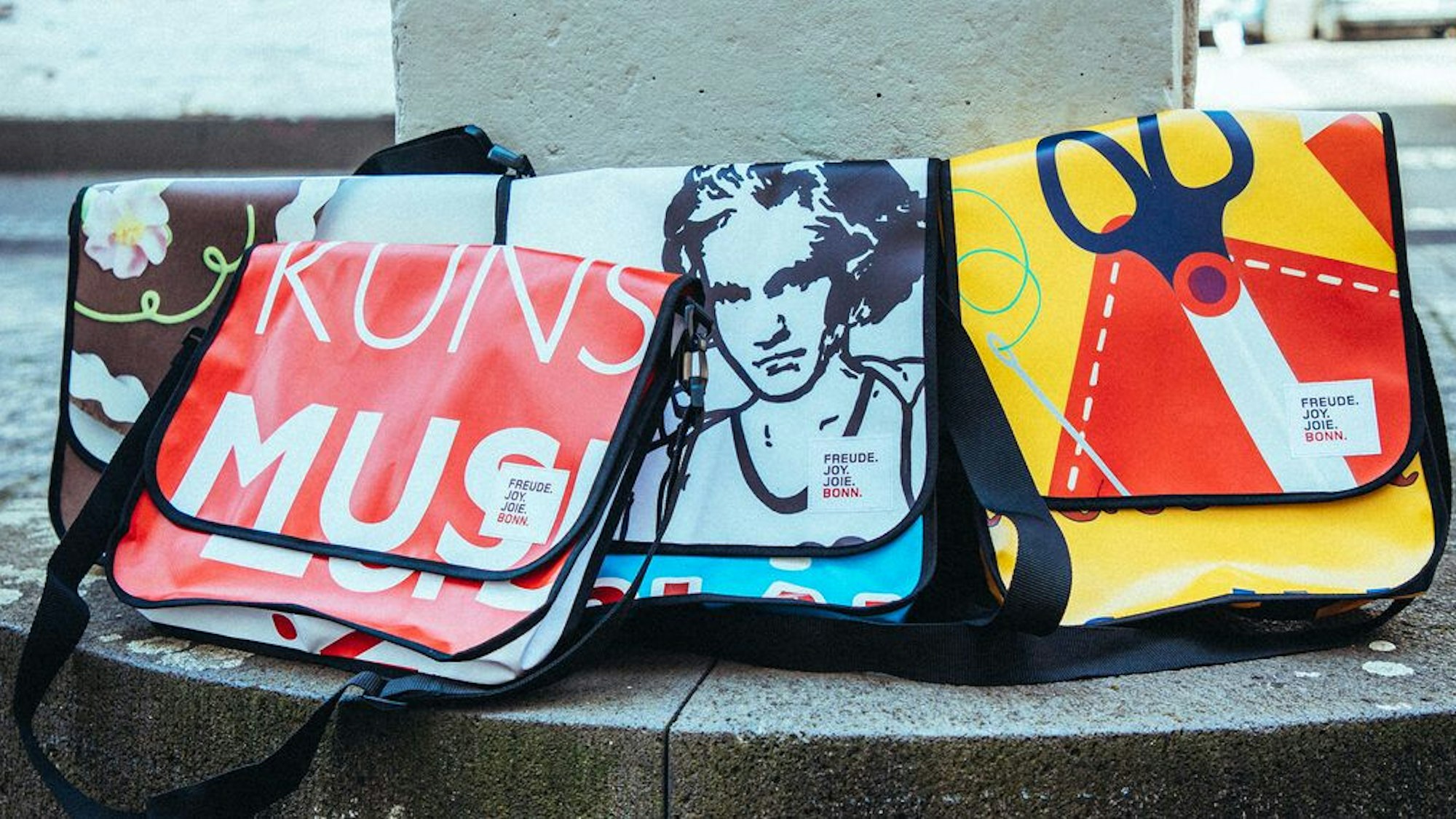 Vier Tasche aus recycelten Werbebannern zeigen unter anderem ein Beethoven-Motiv.