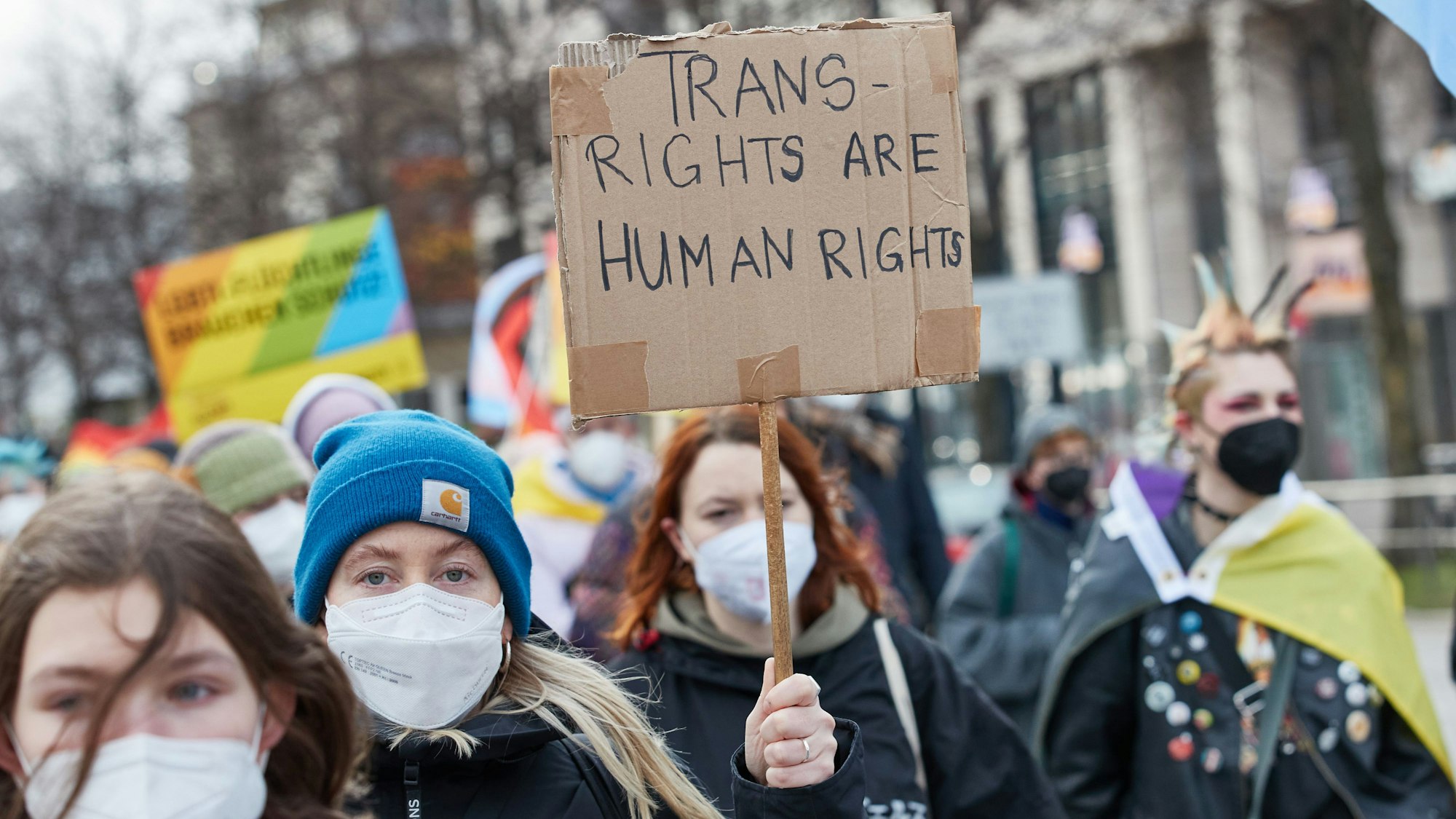 Eine Teilnehmerin hält auf einer Demonstration in Hamburg ein Transparent mit der Aufschrift „Transrights are human rights“.