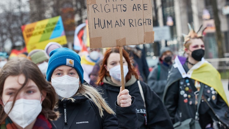 Eine Teilnehmerin hält auf einer Demonstration in Hamburg ein Transparent mit der Aufschrift „Transrights are human rights“.