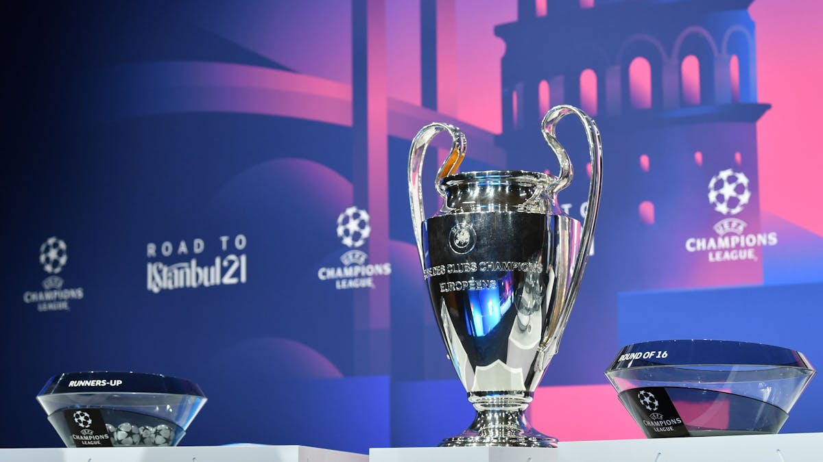 Fußball: UEFA Champions League, Auslosung - K.o.-Runde, Achtelfinale. Der Champions-League-Pokal steht neben den Lostöpfen auf einem Podest.