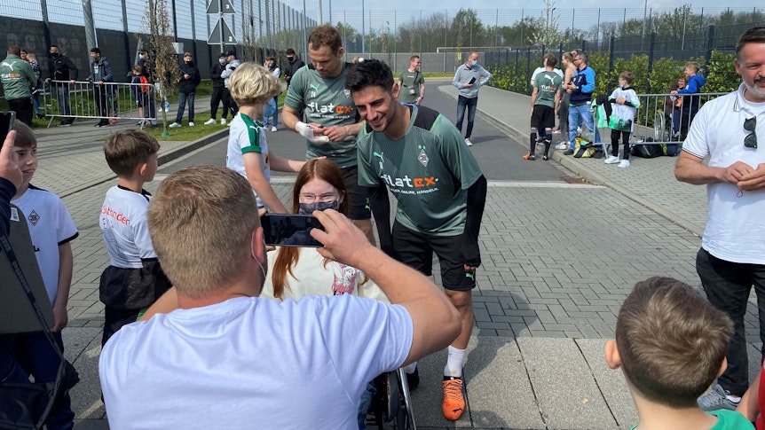Lars Stindl, Kapitän von Borussia Mönchengladbach, posiert mit einem jungen Fohlen-Fan für ein Erinnerungsfoto. Im Hintergrund sieht man Tony Jantschke beim Schreiben von Autogrammen.