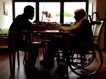 Ein Azubi zum Altenpfleger unterhält sich im Pflegeheim Eilenriedestift in Hannover mit einer Seniorin.