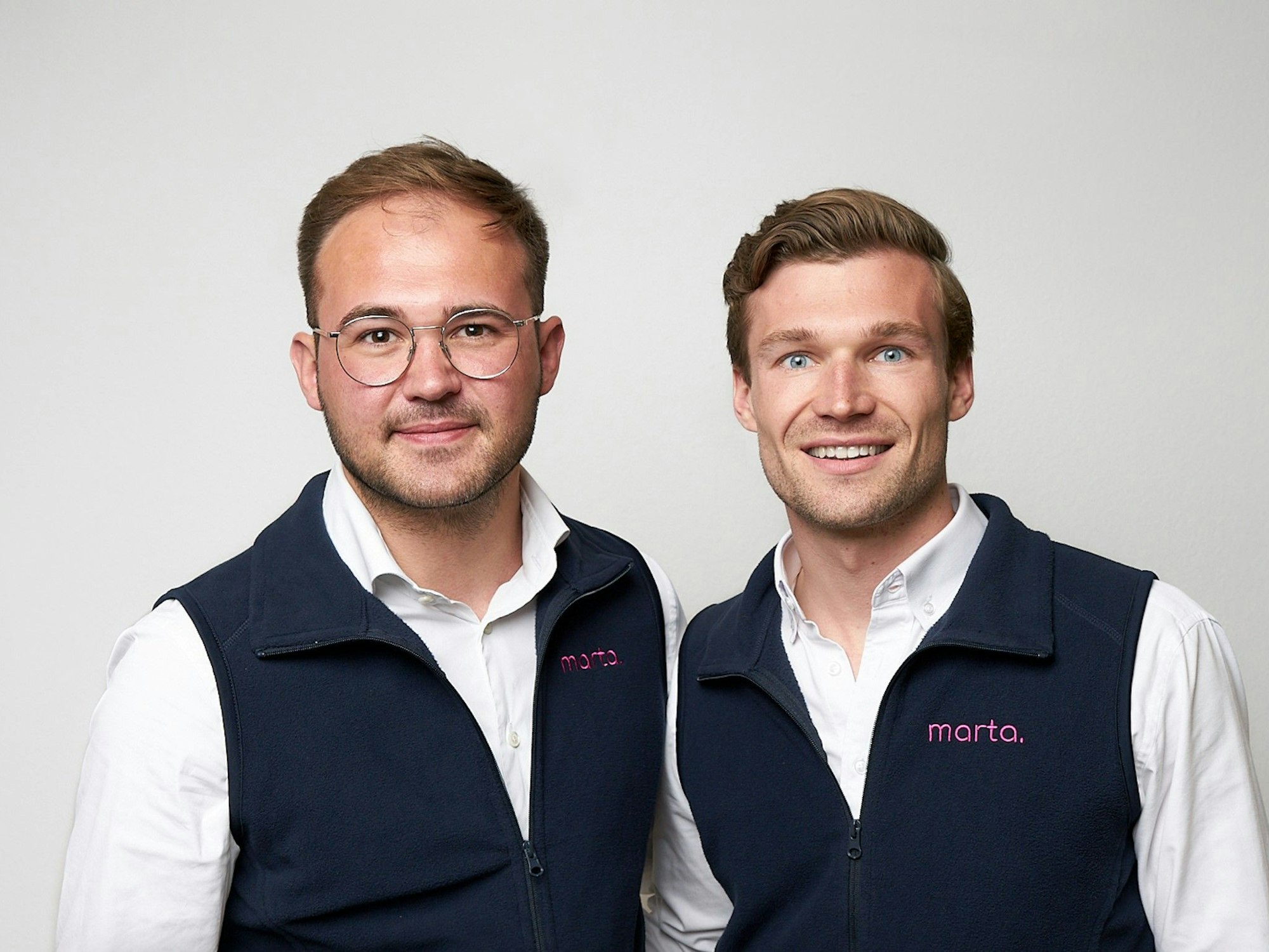 „marta“-Gründer Philipp Buhr und Jan Hoffmann lächeln in die Kamera.