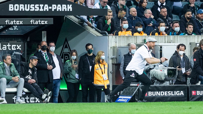Steffen Baumgart, Trainer des 1. FC Köln, gestikuliert an der Seitenlinie während des Derbys (16. April 2022) gegen Gladbach im Borussia-Park. Baumgart trägt eine Mütze.