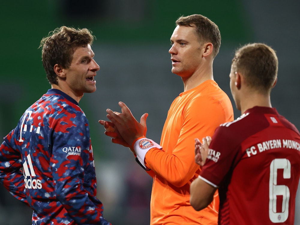 Bayerns Thomas Müller (l-r), Bayerns Torwart Manuel Neuer und Bayerns Joshua Kimmich stehen nach dem Sieg zusammen.