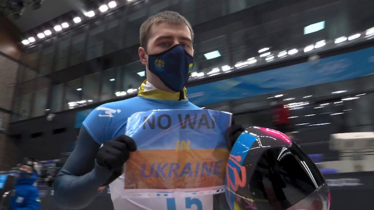 Wladislaw Heraskewitsch hält Schild „No War in Ukraine“ hoch.