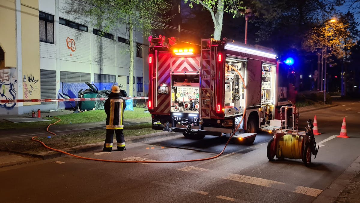 Ein Feuerwehrmann steht neben dem Wrack eines&nbsp;Autos. Zwei junge Männer sind am Ostersonntag in Essen mit einem Auto aus der obersten Etage eines Parkhauses gestürzt und ums Leben gekommen.