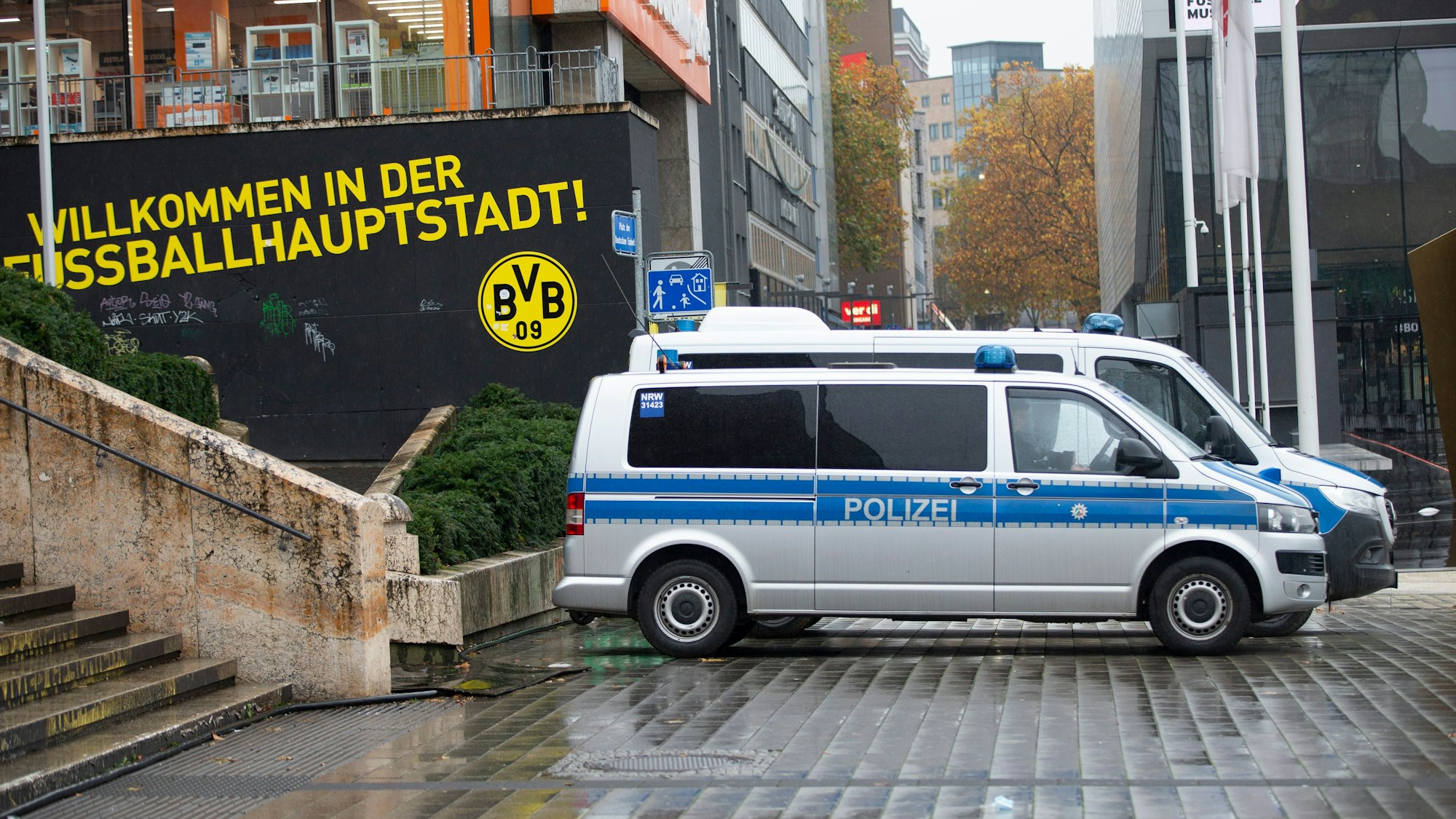 Polizeiautos stehen am Dortmunder Hauptbahnhof. Auf einem Schild ist „Willkommen in der Fußballhauptstadt Dortmund“ zu lesen.
