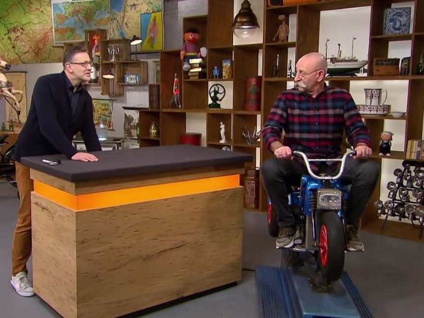 Horst Lichter sitzt auf dem Kiddy Ride Trike. Foto: Screenshot ZDF