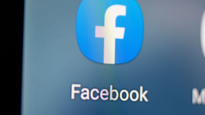 Auf dem Bildschirm eines Smartphones sieht man das Logo der App Facebook. Das Symbolbild ist vom 28. April 2021.