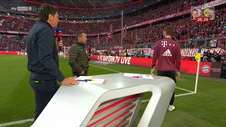 Sven Ulreich steht beim Aufwärmprogramm vor dem Spiel des FC Bayern gegen Borussia Dortmund plötzlich mitten in der TV-Übertragung von Sky mit Sebastian Hellmann und Lothar Matthäus.