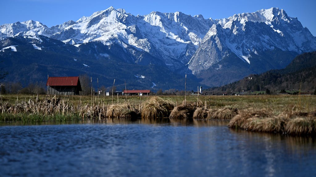 See, Wiese, ein Häuschen und Berge in Garmisch-Partenkirchen (Bayern).