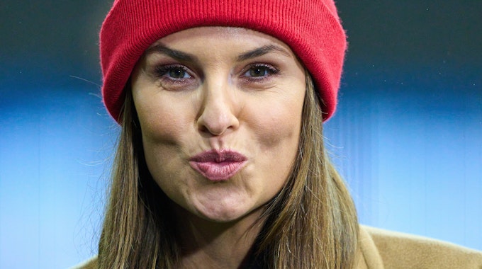 Laura Wontorra formt bei einem Bundesliga-Spiel einen Kuss-Mund in die Kamera.