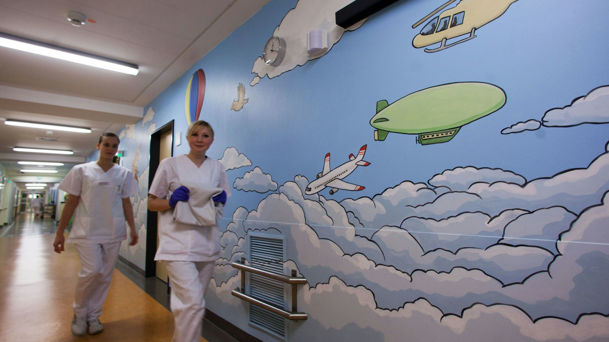 Zwei Krankenschwestern laufen am 13. Dezemeber 2011 an einem großen Wandbild auf einer Station vorbei.