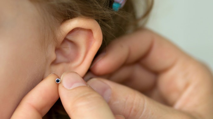 Rückruf von Schmuck: Bei bestimmten Ohrringen ist jetzt Vorsicht geboten. Sie können schlimme allergische Reaktionen auslösen. Unser Symbolbild zeigt Ohrringe bei einem Kind.