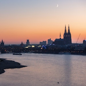 Der Ausblick von der Kölner Seilbahn über den Rhein bei Sonnenuntergang. EXPRESS.de stellt 11 Dinge vor, die jeder mal in Köln gesehen und erlebt haben muss.