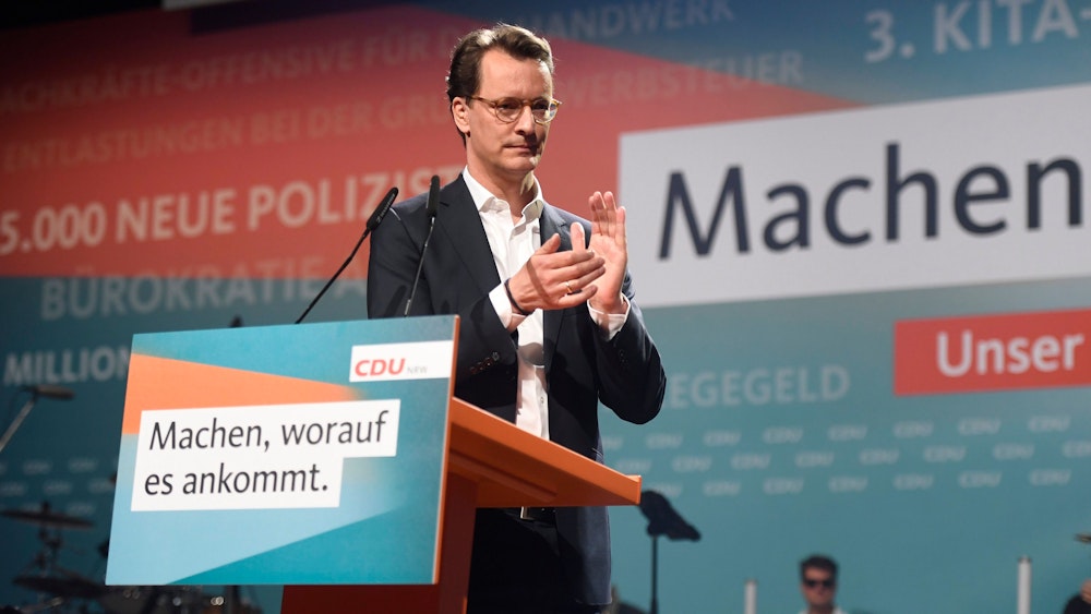 Hendrik Wüst applaudiert auf einem Podium bei einer CDU-Veranstaltung.