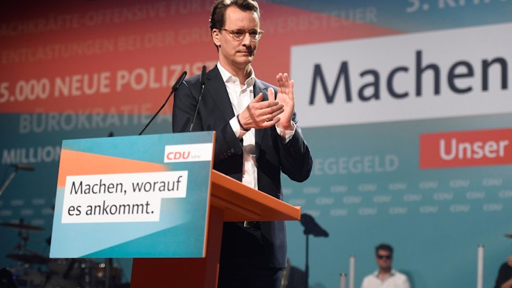 Hendrik Wüst applaudiert auf einem Podium bei einer CDU-Veranstaltung.