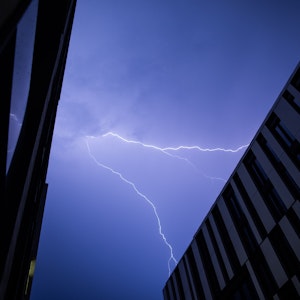 Blitze erhellen den Himmel über einer Häuserreihe. Ein Gewitter über Düsseldorf hat in der Nacht einen lauten Knall verursacht.