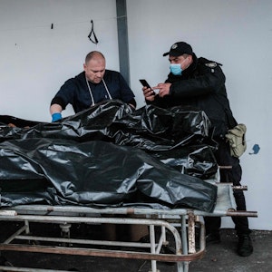 Polizeibeamte fotografieren am 18. April für Ermittlungen einen der Toten, die in Butscha gefunden worden sind. Russischen Streitkräften wird vorgeworfen, in der Stadt zahlreiche Kriegsverbrechen begangen zu haben.