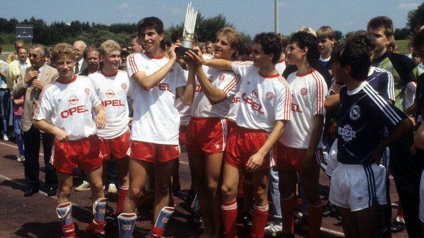 Max Eberl (l.) und Markus Babbel (3.v.l.) im Trikot des FC Bayern München am 16. Juli 1989 bei der Siegerehrung zur deutschen B-Jugend-Meisterschaft 1988/1989. Babbel hat den Siegerpokal in den Händen