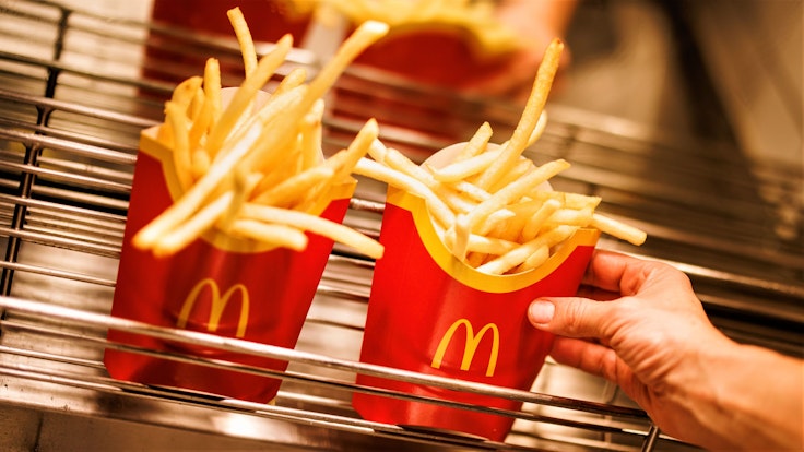 McDonald's und Burger King stehen für günstiges und schnelles Fast-Food-Essen. Doch auch hier mussten Kundinnen und Kunden in den letzten Monaten und Jahren immer mehr draufzahlen. Unser Archivbild vom Dezember 2021 zeigt Tüten mit Pommes frites in einer McDonald's-Filiale.