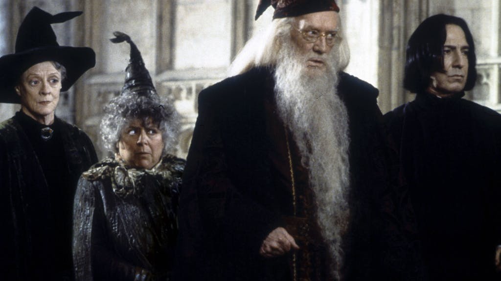 Szene aus dem Film Harry Potter und die Kammer des Schreckens. Zu sehen sind hier Maggie Smith (als Minerva McGonagall), Miriam Margolyes (als Pomona Sprout), Richard Harris (als Albus Dumbledore) und Alan Rickman (als Severus Snape) v.l.