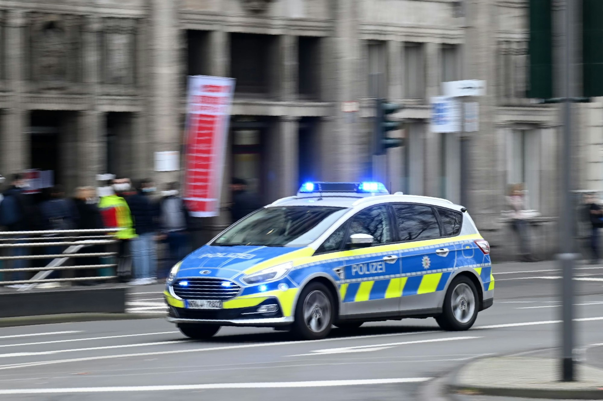 Ein Einsatzfahrzeug der Polizei fährt am Kölner Neumarkt vorbei.