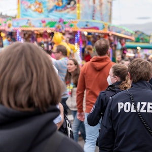 Kölner Polizistinnen und Polizisten gehen über die Deutzer Kirmes in Köln.