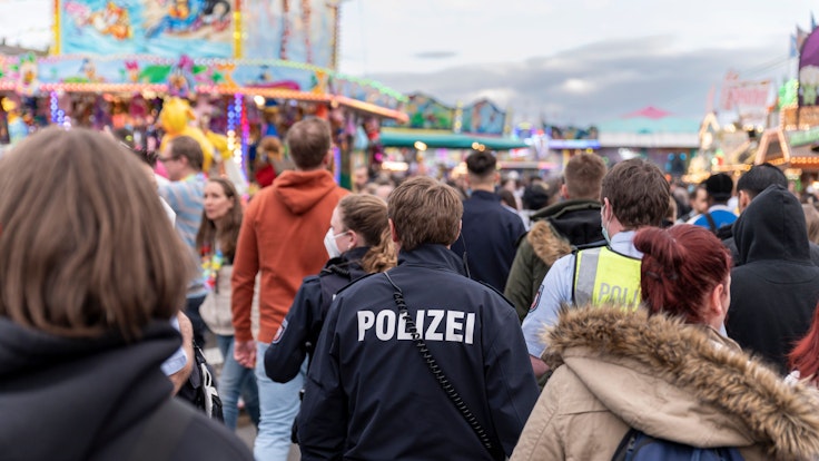 Kölner Polizistinnen und Polizisten gehen über die Deutzer Kirmes in Köln.