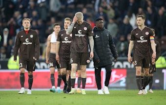 Die Spieler des FC St. Pauli schleichen gefrustet über den Platz.