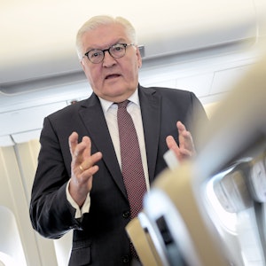 Bundespräsident Frank-Walter Steinmeier spricht im Anzug auf dem Flug am 4. Mai 2022 nach Rumänien.