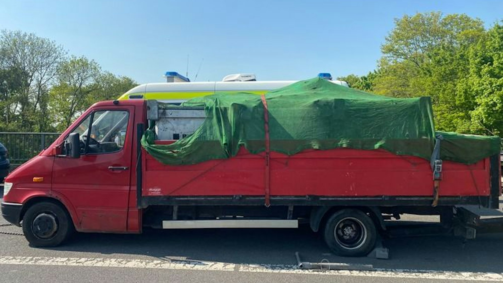 Ein roter Lkw steht an der Straße. Das Fahrzeug wurde von der Autobahnpolizei Köln aus dem Verkehr gezogen – es wies erhebliche Mängel auf.