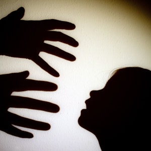 Schatten von Händen einer erwachsenen Person und dem Kopf eines Kindes an einer Wand eines Zimmers, Symbolfoto von Januar 2014.