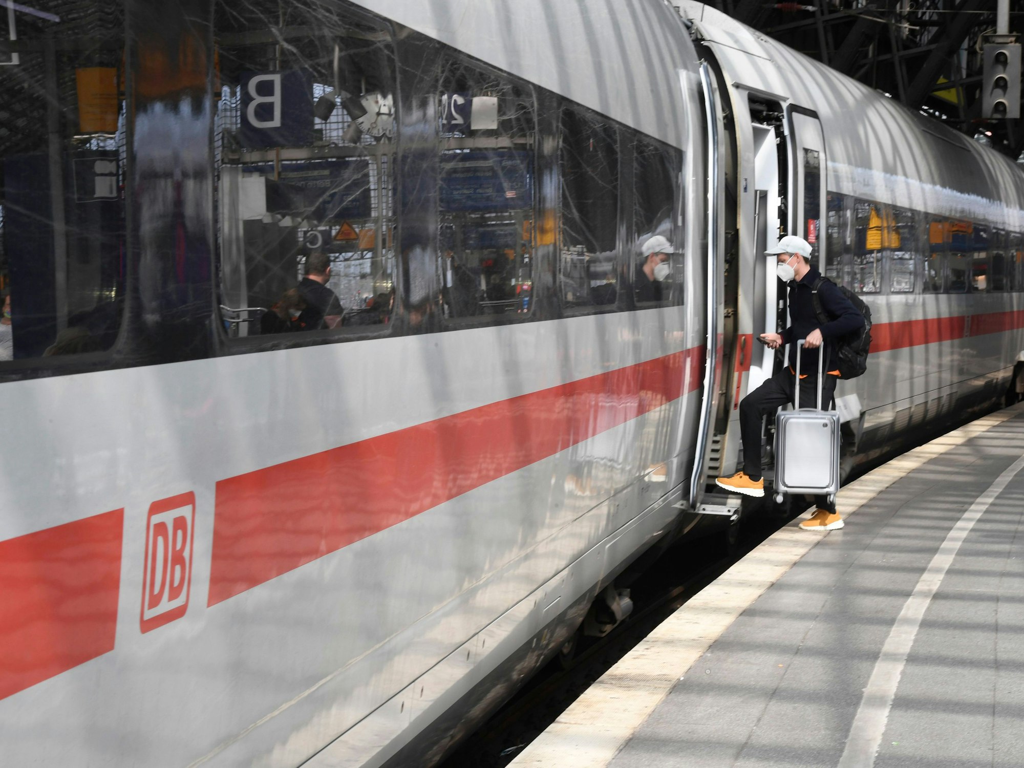 Ein Reisender steigt an Bahnsteig im Kölner Hauptbahnhof in einen Zug.