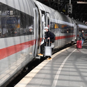 Ein Reisender steigt an Bahnsteig im Kölner Hauptbahnhof in einen Zug.