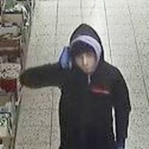 Mann geht durch Supermarkt in Köln. Kurz darauf bedrohte er Kassiererin mit Pistole.
