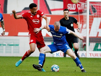 Fortuna Düsseldorfs Emmanuel Iyoha (l) und der Darmstädter Thomas Poppler Isherwood kämpfen in der 2.-Liga-Partie am 6. Mai 2022 um den Ball.