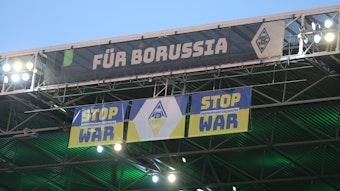 Ein „Stop War“-Banner im Borussia-Park. Diese Aufnahme stammt vom 2. Mai 2022 und ist rund um die Partie von Borussia Mönchengladbach gegen RB Leipzig entstanden. Das Banner ist am Tribünendach befestigt.