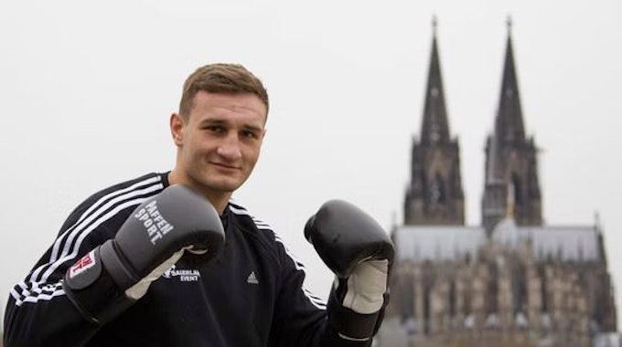 Der Boxer Denis Radovan posiert vor dem Kölner Dom.