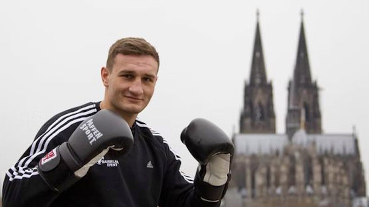 Der Boxer Denis Radovan posiert vor dem Kölner Dom.