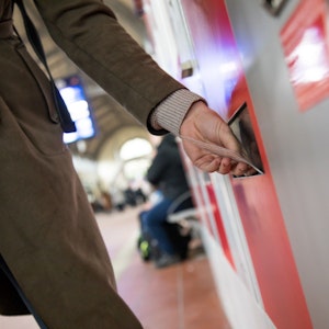 Eine Frau nimmt am 28. März 2018 ein Bahnticket aus einem Ticketautomaten.