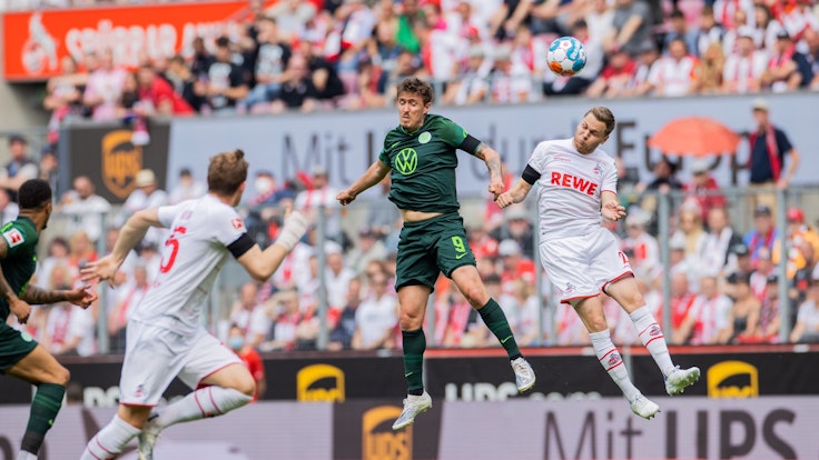 Kölns Benno Schmitz (r) und Wolfsburgs Max Kruse versuchen an den Ball zu kommen.