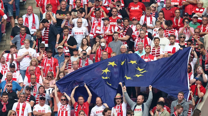 Fans des 1.FC Köln feiern mit einer EU-Flagge.